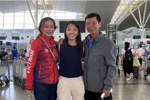 黄茹（中）跟父母在机场合影。