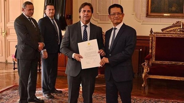 杨国青大使向乌拉圭总统拉卡列·波乌递交越南国家主席阮春福的国书。（图片来源：越通社）