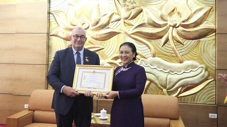 越南友好组织联会主席阮芳娥大使向比利时驻大使保罗·詹森先生授予 “致力于各民族之间的和平与友谊”纪念章。（图片来源：外交部）