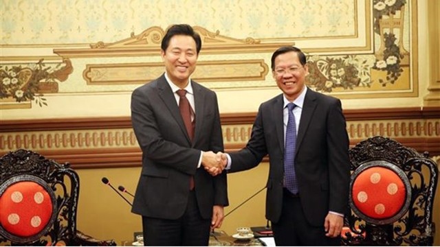 胡志明市人民委员会主席潘文买与韩国首尔市长吴世勋握手。