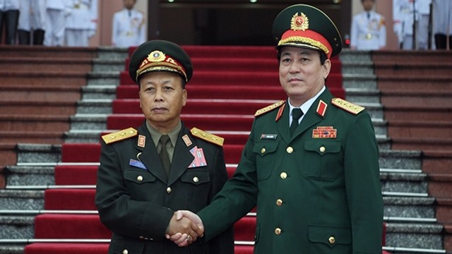 越南人民军总政治局主任梁强与老挝人民军总政治局主任通莱·西力冯握手。
