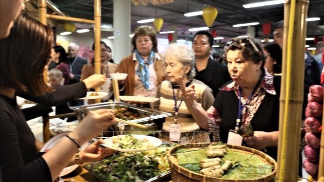 前来参加活动的俄罗斯人民品尝越南美食。（图片来源：VOV）