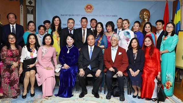 阮春福总理同旅瑞越南人代表合影。（图片来源：越通社）