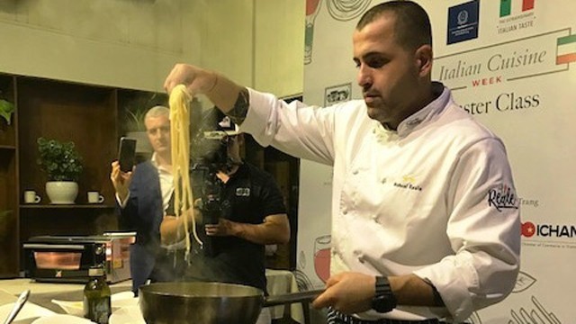 意大利餐厅的厨师展示意面烹调技术。