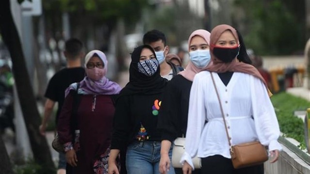 印尼首都雅加达市民佩戴口罩预防感染新冠病毒。