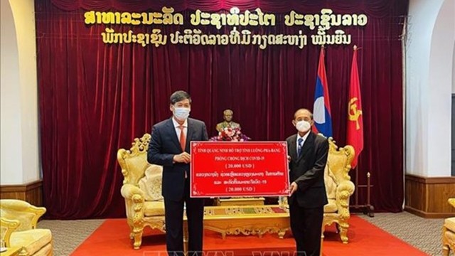 阮登雄总领事向老挝琅勃拉邦省省长坎汗·占塔维苏克转交援助资金。