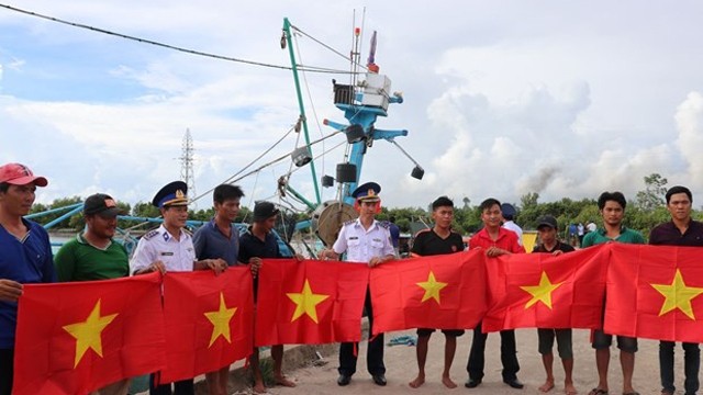 海警第四区司令部向坚江省安明县渔民赠送国旗。