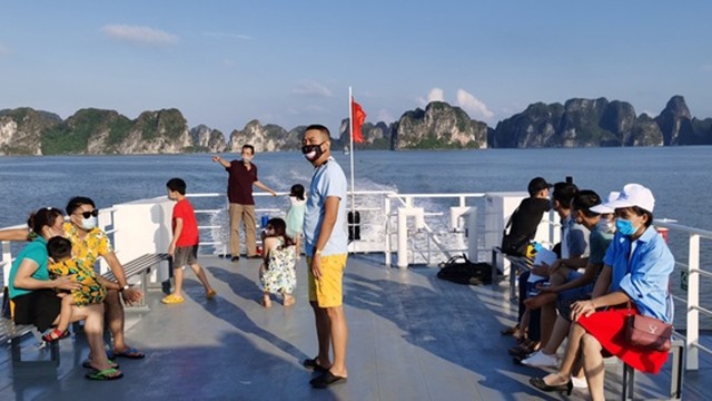 游客乘船参观下龙湾。