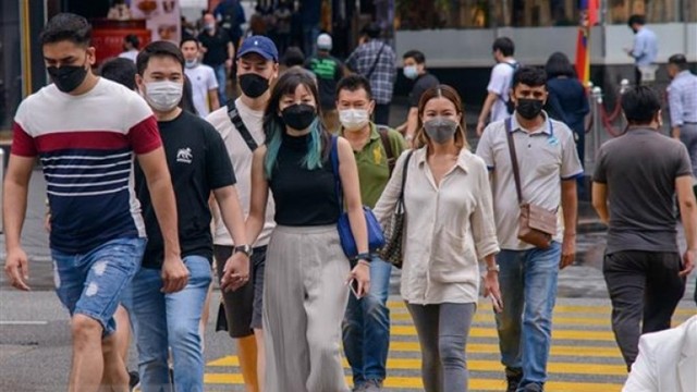 马来西亚吉隆坡居民戴着口罩逛街。