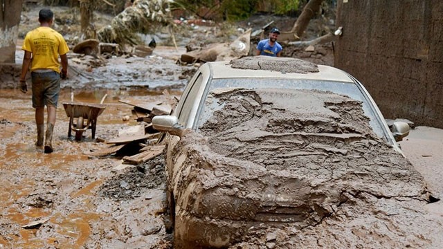 巴西米纳斯吉拉斯州哈波索斯市居民2022年1月13日在发生洪水后的大街上打扫卫生。（图片来源：路透社）