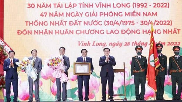 国会主席王廷惠向永隆省党委、政府和人民颁发国家主席的一级劳动勋章。（图片来源：越通社）