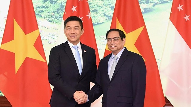 范明正总理与新加坡国会议长陈川仁握手。